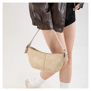 Minimalist cream faux leather tote bag with shoulder strap shown in a lifestyle studio shot