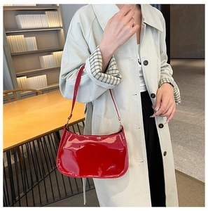 Red patent leather baguette bag styled with a beige trench coat for a chic urban look