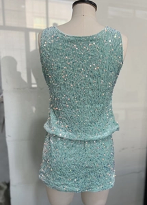 Detail of mint green sequined fabric on a two-piece skirt set showing texture