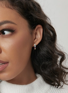 Close-up of model wearing colorful enamel bamboo hoop earrings in gold plated finish
