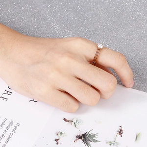 Rose gold pearl ring with hollow chain design worn by a model on a decorative background