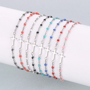 Detailed view of silver chain bracelets with colorful resin beads and cross pendants