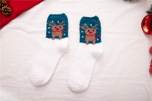 Details von warmen Korallenfleece-Weihnachtssocken mit Elchmustern und Dekorationen