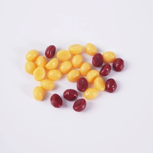 Mini hard wax beans in yellow and red for painless hair removal treatment on white background