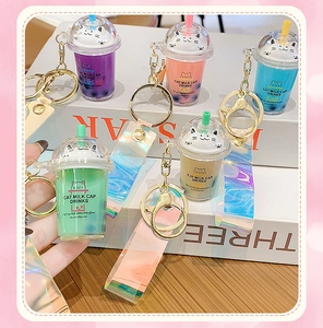 Detail of cute cat milk tea cup keychains with colorful laser straps and gold metal rings