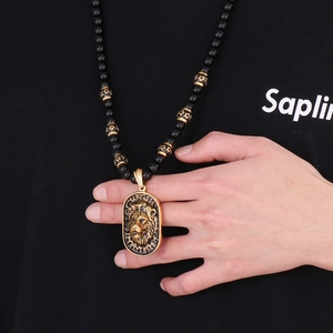 Close-up of a men's black beaded necklace featuring a majestic golden lion head pendant