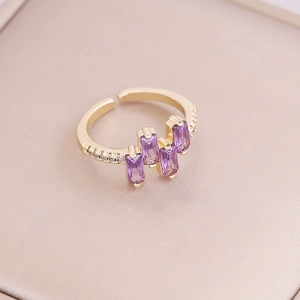 Macro detail of adjustable gold ring featuring three rectangle purple zircon stones