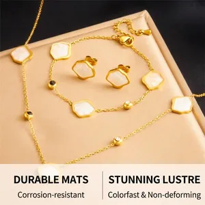 Detailed set of gold clover jewelry featuring white shell inserts and small crystals