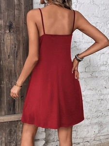 Detail view showing the deep red mini dress backless cut and thin straps on model