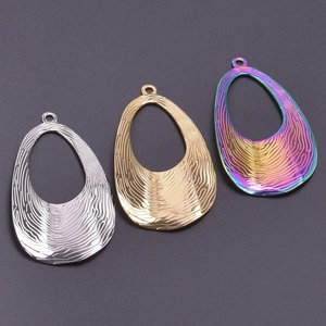 Macro view of textured geometric stainless steel pendants in gold, silver and rainbow finish