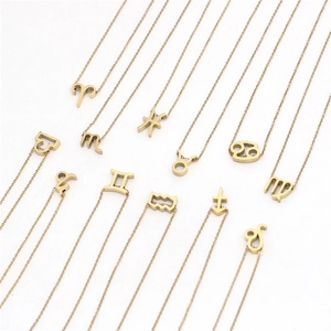 Vue à plat de douze colliers avec pendentifs signes du zodiaque en acier plaqué or sur blanc