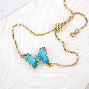 Detail of blue crystal butterfly pendant on adjustable gold bolo chain bracelet