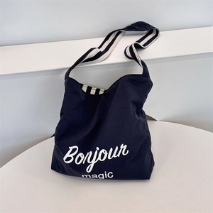 Close-up of navy canvas Hobo bag with Bonjour magic print and striped shoulder strap