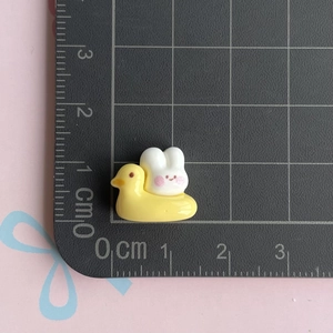 Miniature resin white rabbit on yellow duck figurine showing 2.5cm scale on cutting mat