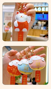 Close-up of cute Maneki Neko leather keychains with golden lobster clasp and charms