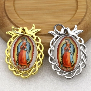Close-up of Virgin Mary religious pendants with hollow lace frames in gold and silver finish