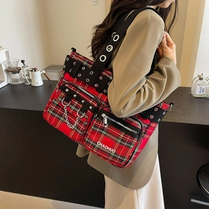 Punk style red plaid tote bag with heavy rivets and wide metal eyelet shoulder strap