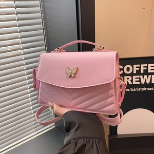 Pink quilted shoulder bag with metal butterfly clasp and v-shaped embroidery patterns