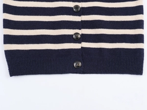 Detail of navy striped knit cardigan featuring marble buttons and ribbed hem finish