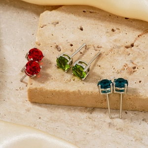Macro detail of three-pair crystal stud earring set in red, green and blue stones