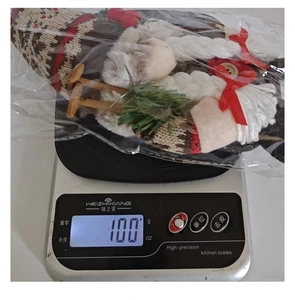 Detailed view of a 100g Christmas gnome doll on a scale for weight measurement
