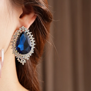 Detailed close-up of French vintage drop earring with a large navy blue waterdrop gem