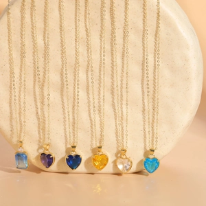 Detail of colorful heart and rectangular glass pendants on golden metal chains