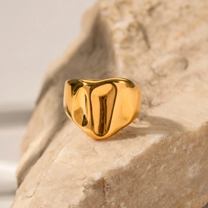 Bague large en acier plaqué or 18K avec texture martelée sur support en pierre
