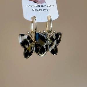 Detail shot of leopard print butterfly pendant earrings with S925 silver needles