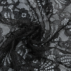 Close-up of black floral lace fabric with intricate hollow patterns and fine texture