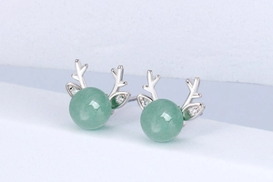 Macro shot of silver deer antler earrings featuring green aventurine stones and zircons