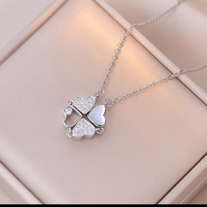 Detail of clover pendant necklace with zircon heart petals in a luxury jewelry box