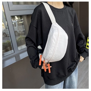 White nylon chest bag with bright orange zipper pulls and adjustable strap detail