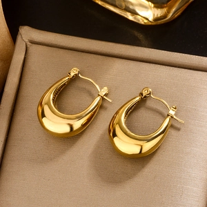 Detailed macro view of mirror-polished gold U-shaped earrings on a jewelry tray