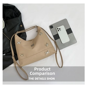 Close-up of beige hobo bag featuring silver butterfly studs and matching shoulder strap