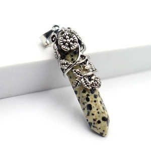 Macro d'un pendentif jaspe dalmatien hexagonal avec décor floral en argent