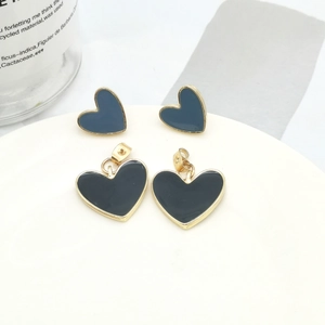 Macro detail of heart-shaped earrings with gold edges and colorful enamel drip finish