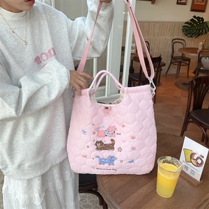 Detail of pink quilted tote bag with cute cat embroidery and soft cloud texture