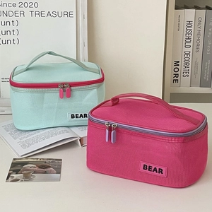Detail of mint and pink mesh makeup bags with Bear patches and double zippers