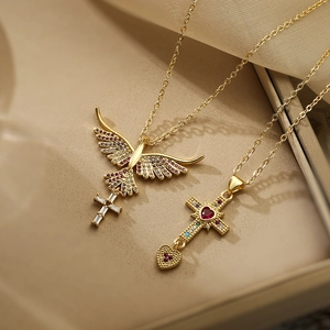 Macro shot of gold-plated cross necklaces with colorful zircon bird and heart pendants