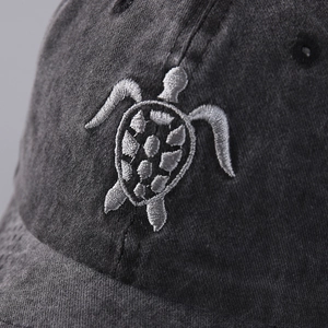 Macro shot of flying turtle embroidery on washed cotton twill baseball cap fabric