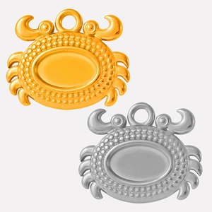 Detailed view of crab charms in gold and silver finish with textured edges and top loops