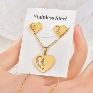 Detail of gold heart necklace and earring set with flower patterns on a display card