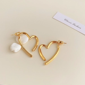 Macro detail of 18K gold plated hollow heart earrings with high polish mirror finish
