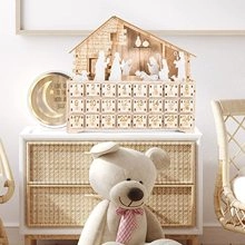Wooden 24-day advent calendar with LED Nativity scene and numbered drawers in warm home setting