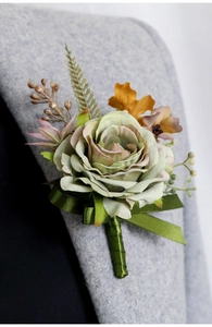 Detailed view of an artificial light green rose boutonniere on a gray suit lapel