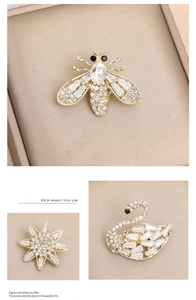 Detailed view of bee, star, and swan brooches with sparkling cubic zirconia on gold metal