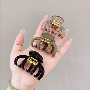 Three medium octopus hair claws in transparent spotted, matte khaki, and glossy black colors