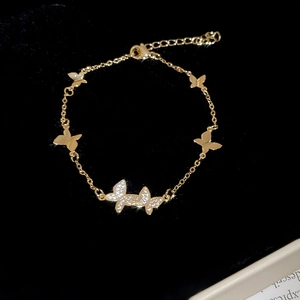Detailed macro view of a gold butterfly bracelet with pavé-set zircon crystals and clasp