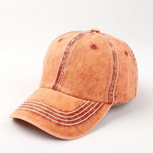 Detail of vintage orange cotton baseball cap with white contrast stitching and washed canvas